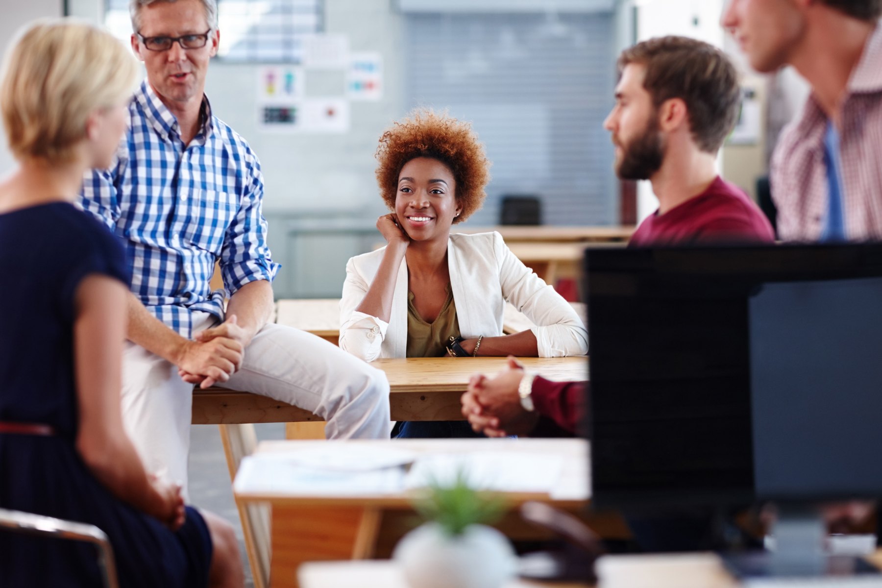 Colleagues having a warm, supportive conversation in a bright office