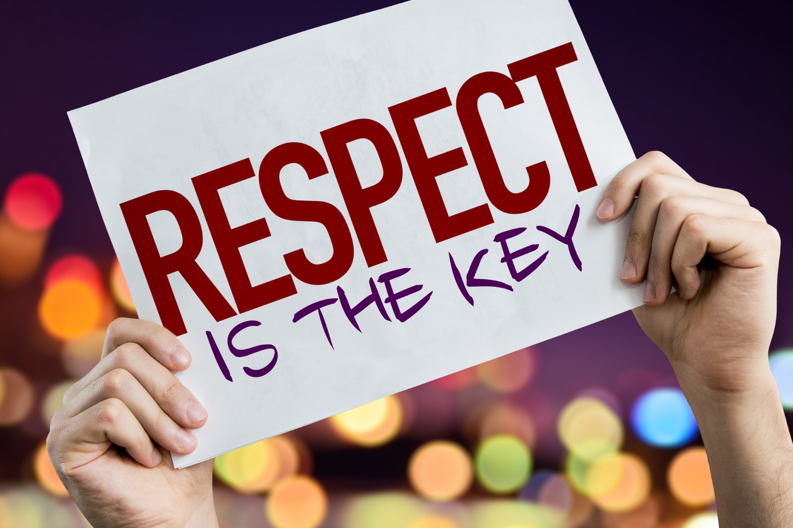 Hands holding up a sign that reads: respect is the key