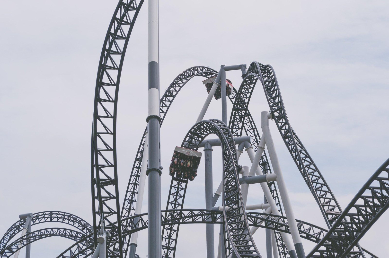A steel rollercoaster with looping twists against an open sky